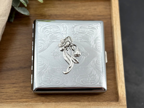 Victorian-inspired metal card case featuring a stylized bluebell and decorative stamped metalwork