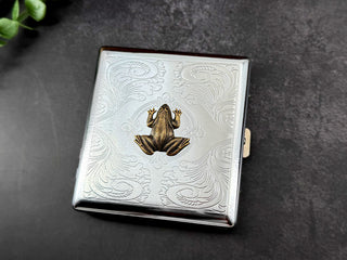 Handmade silver metal cigarette case featuring a raised bronze-toned frog