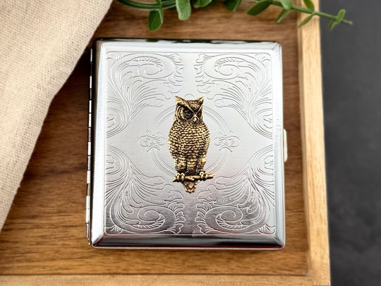 Bronze owl card holder with ornate silver metal background