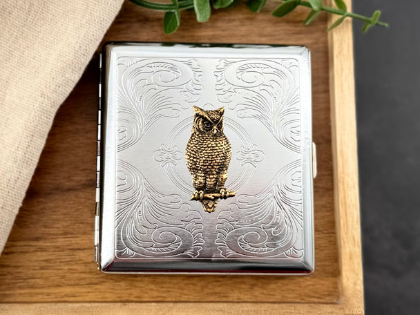 Bronze owl card holder with ornate silver metal background