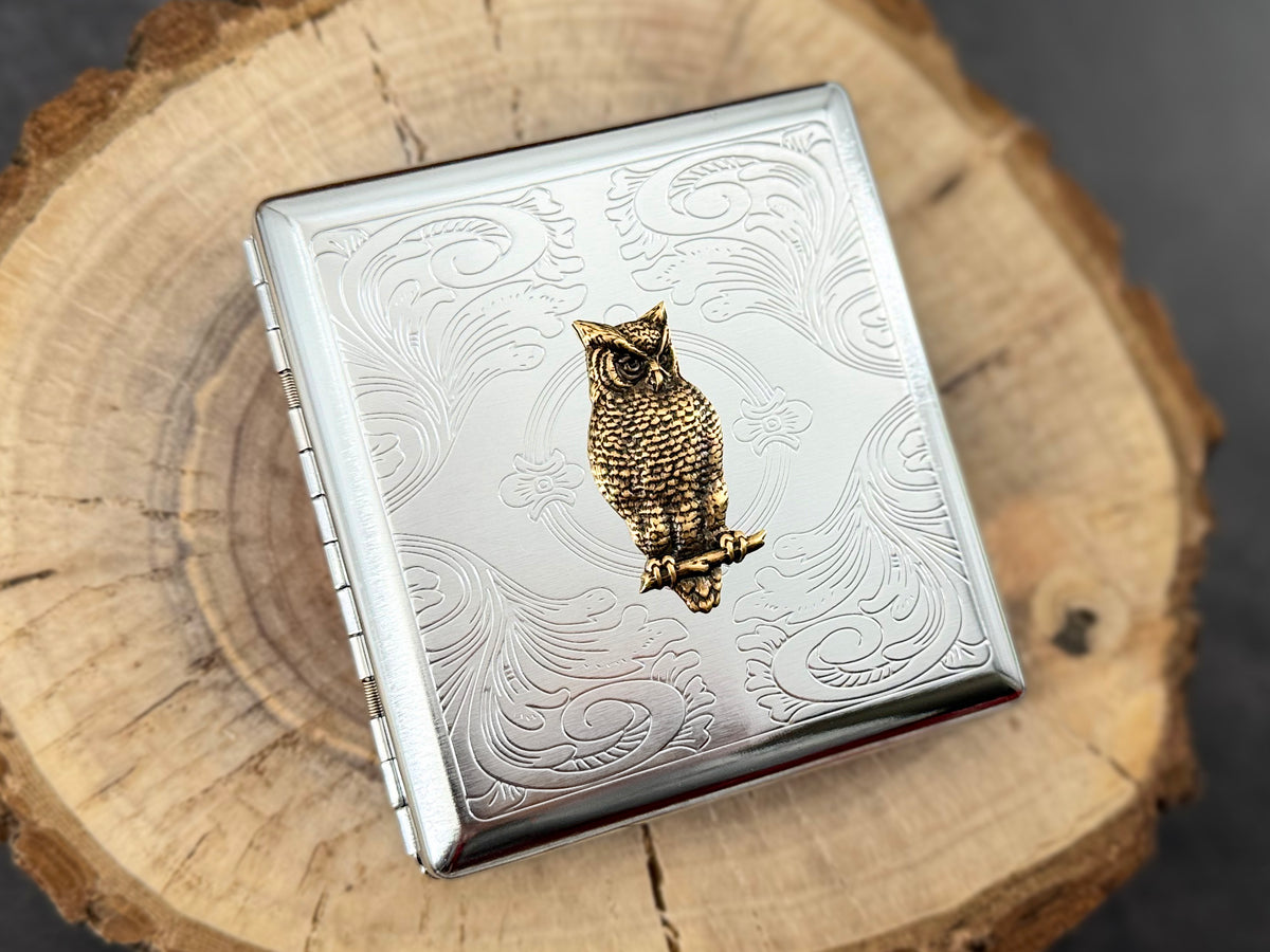 Handmade bronze owl cigarette case on wooden background