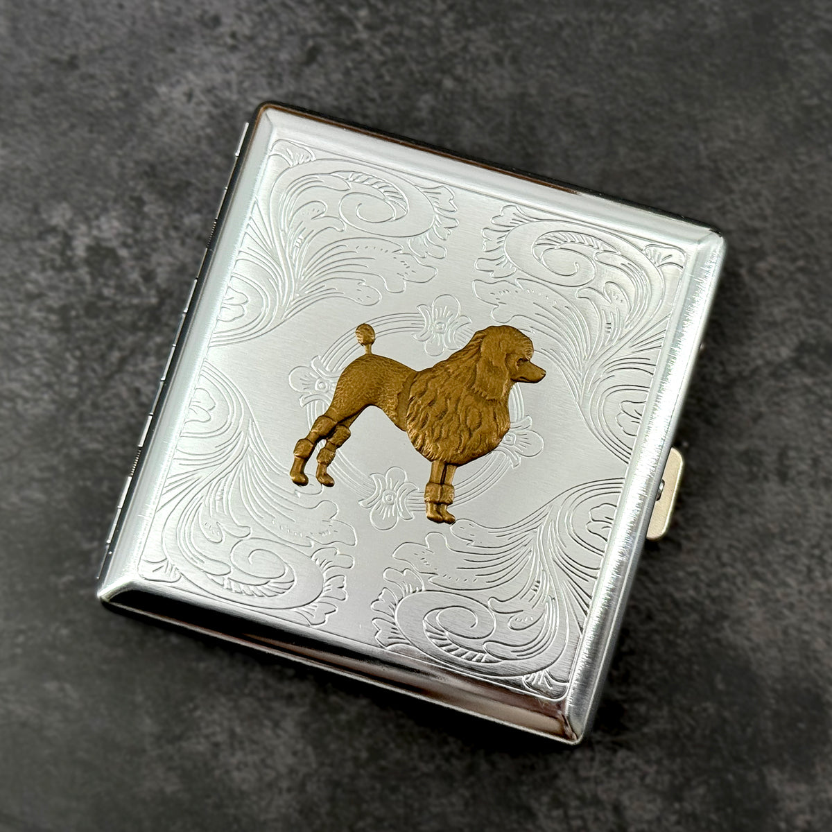 Handmade silver cigarette case featuring a raised bronze poodle