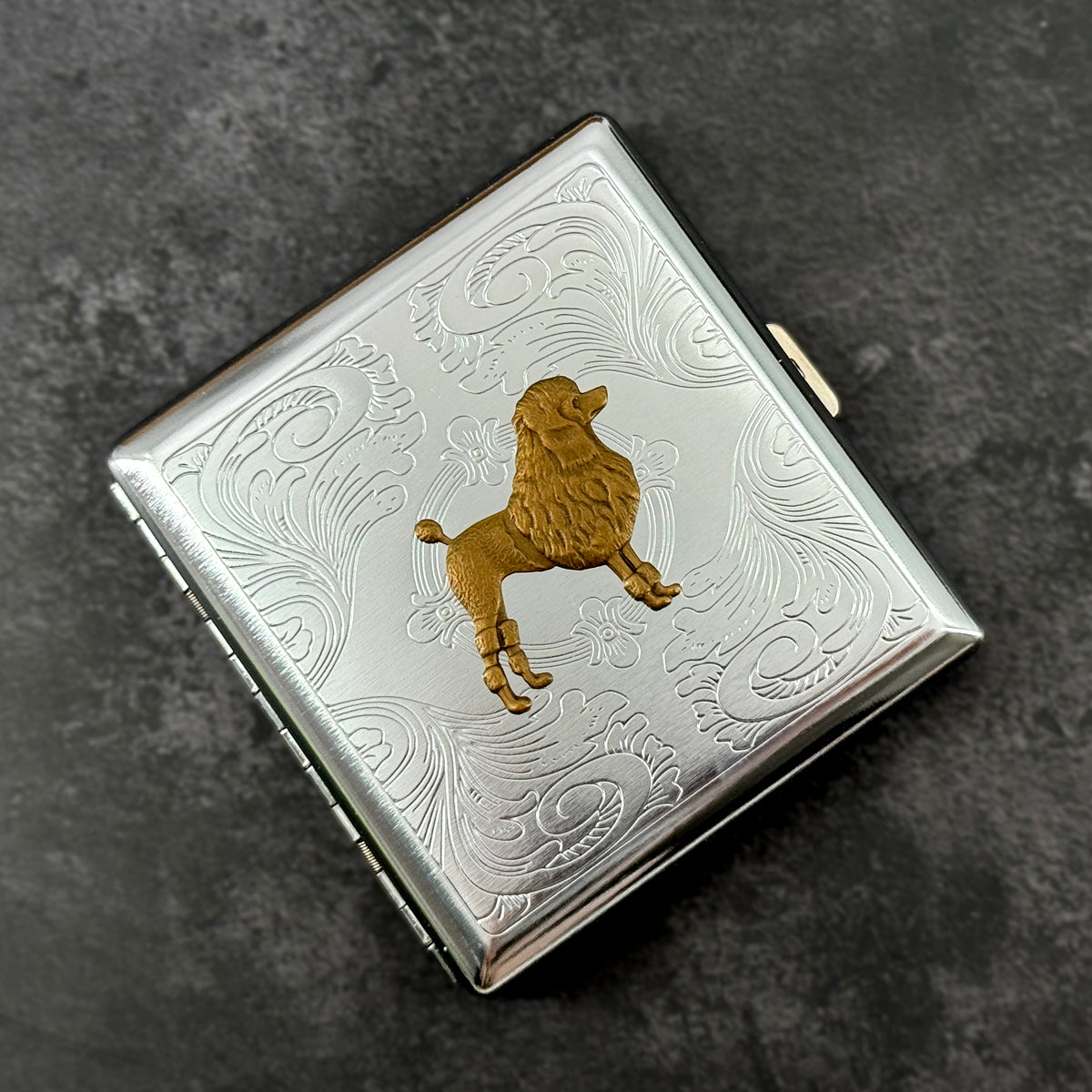Bronze poodle dog case with ornate stamped metal scrollwork