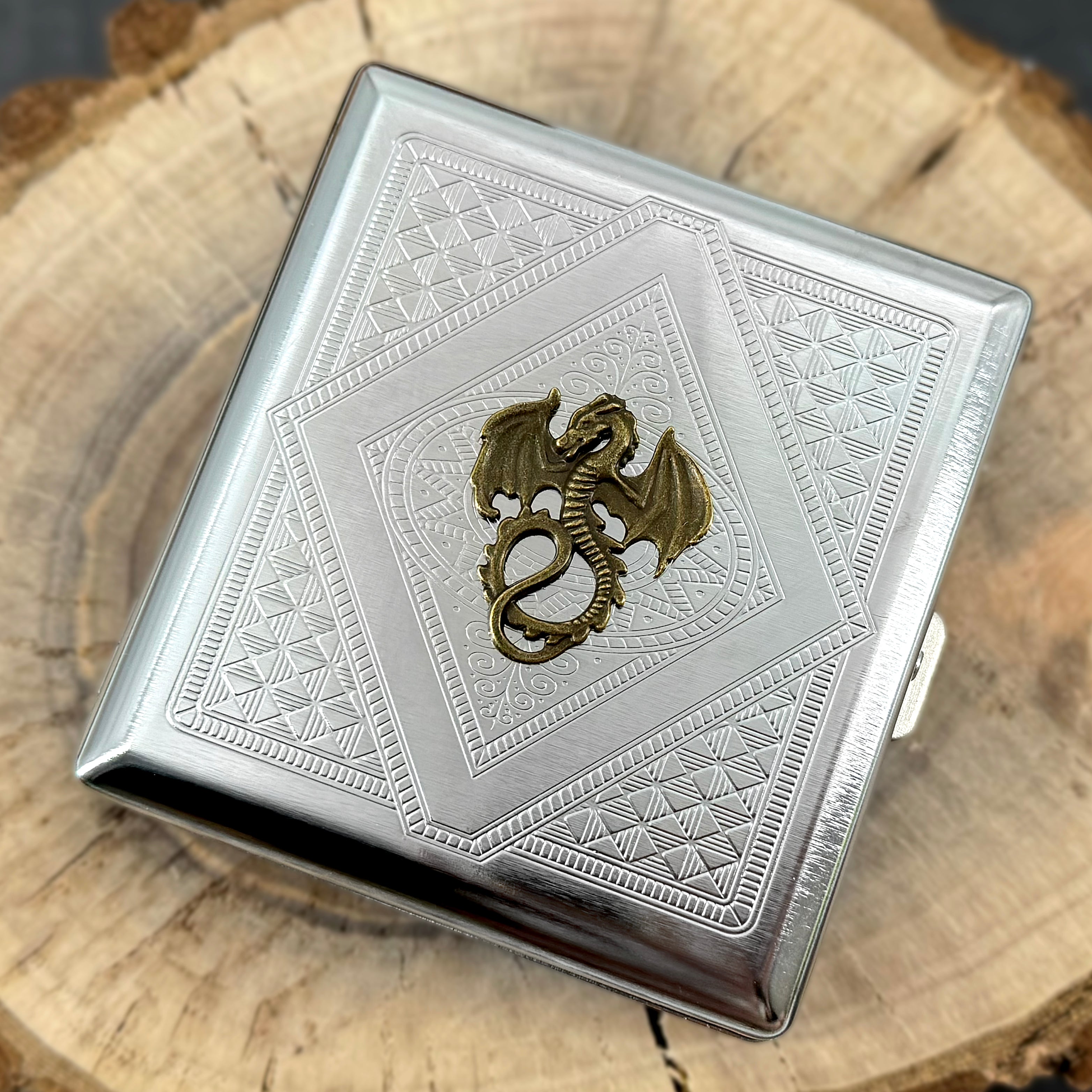 Detailed bronze dragon with raised wings and curled tail on silver metal card holder