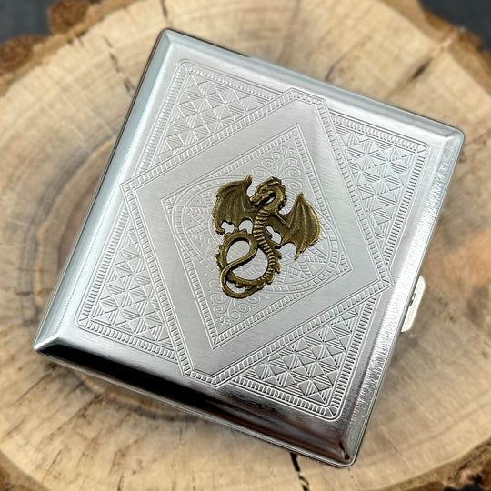 Detailed bronze dragon with raised wings and curled tail on silver metal card holder