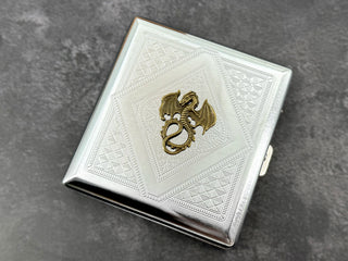Silver metal cigarette case featuring an antique bronze winged dragon centerpiece
