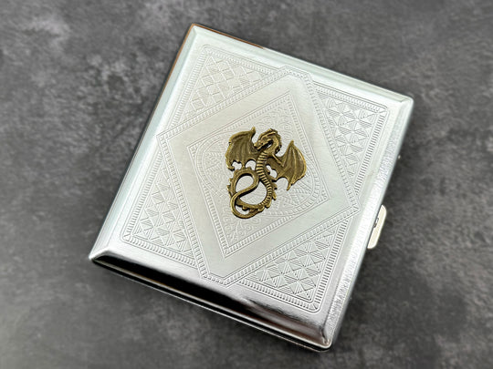 Silver metal cigarette case featuring an antique bronze winged dragon centerpiece