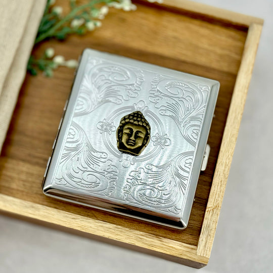 Buddha head cigarette case with raised meditation-inspired detail and engraved ornamental background