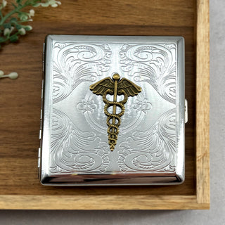 Vintage-inspired caduceus pocket case with ornate engraved background