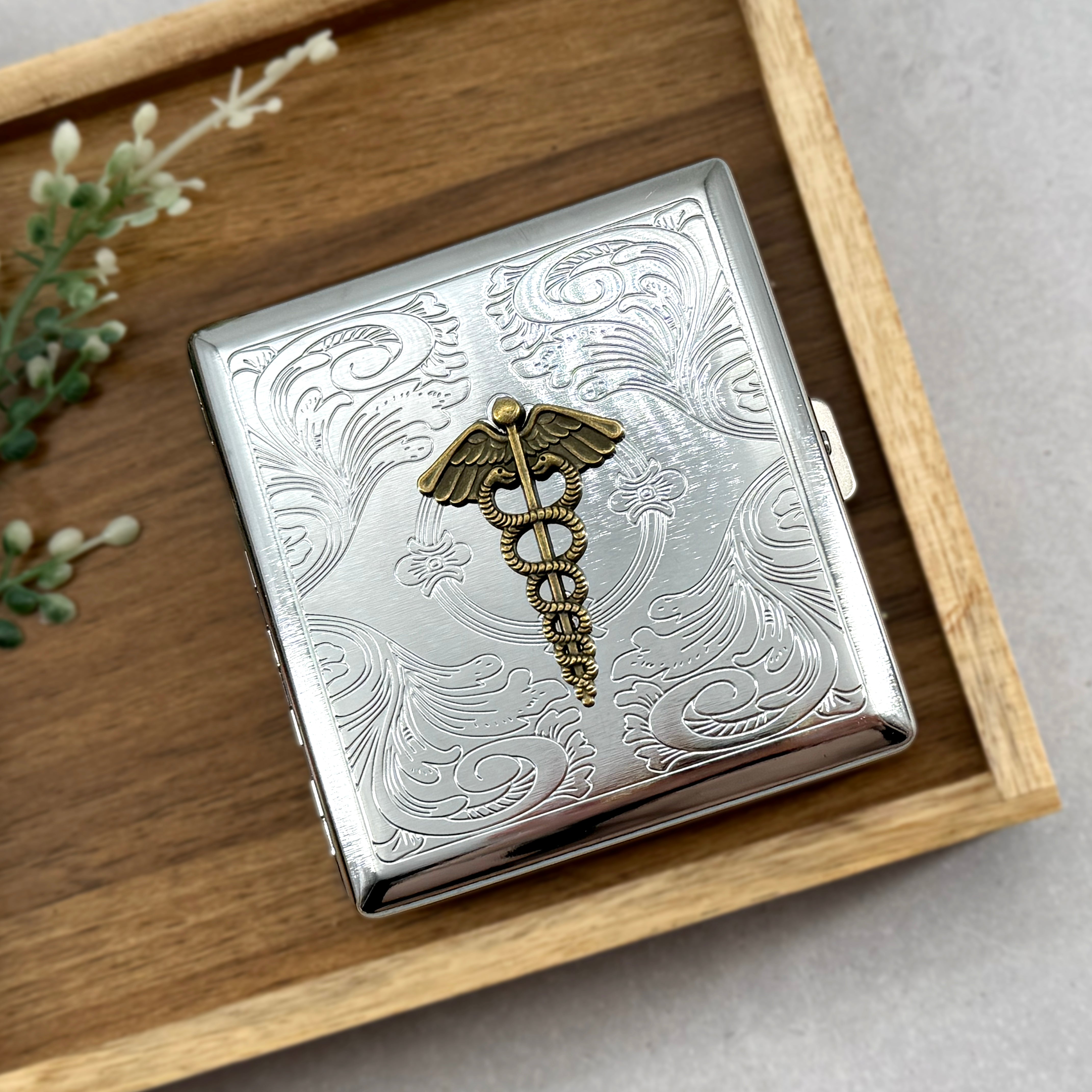 Handmade medical symbol case displayed on wooden tray with decorative engraving