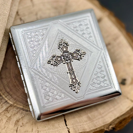 Ornate cross cigarette case with raised cross detail and engraved geometric background