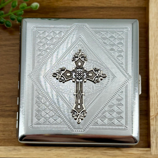 Faith-inspired cigarette case with ornate raised cross and geometric detailing