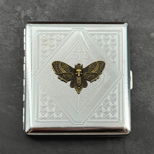 Silver-toned gothic card holder featuring a raised skull moth on an angular geometric pattern