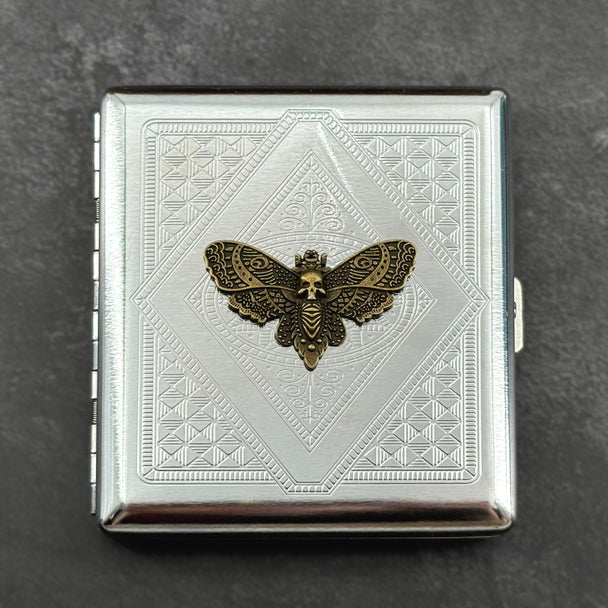 Silver-toned gothic card holder featuring a raised skull moth on an angular geometric pattern
