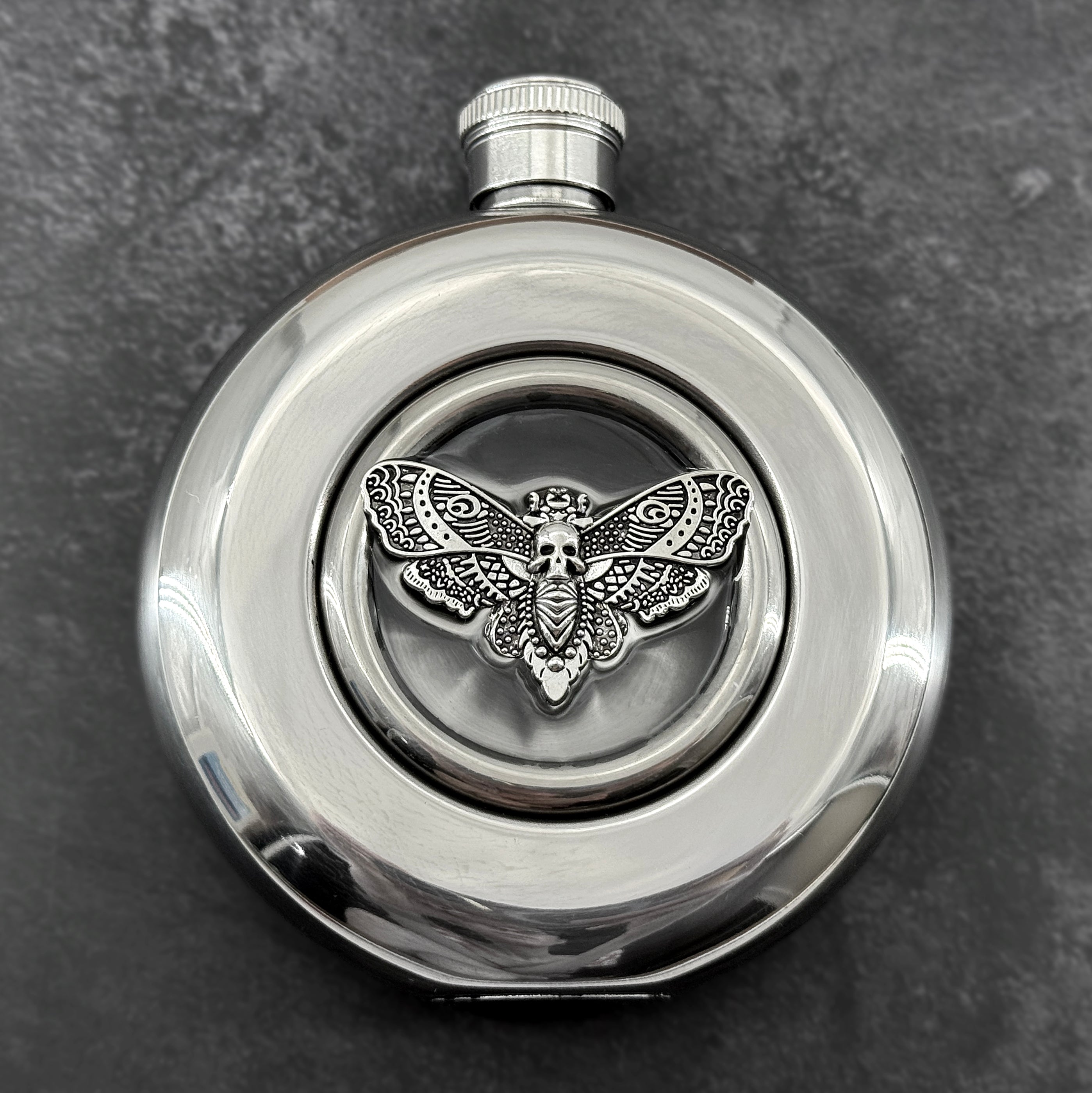 Mirror-finish 5 oz hip flask featuring a resin-embedded skull moth centerpiece