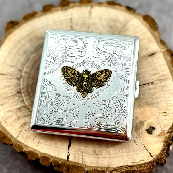 Gothic moth pocket case displayed on a natural wood slice