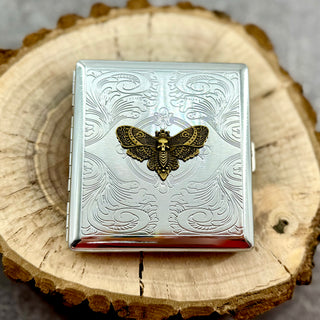 Death's-head moth cigarette case with raised moth detail and engraved ornamental background