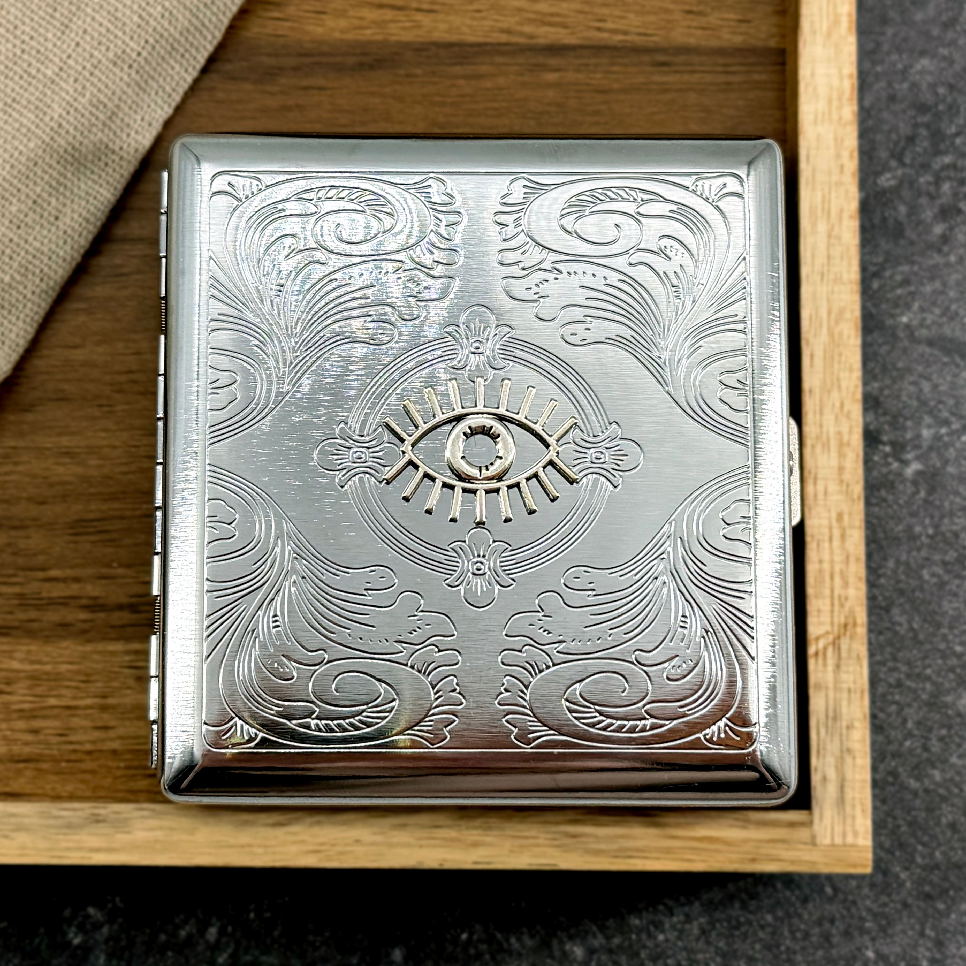 Handmade metal cigarette case featuring a raised evil eye symbol and ornate detailing