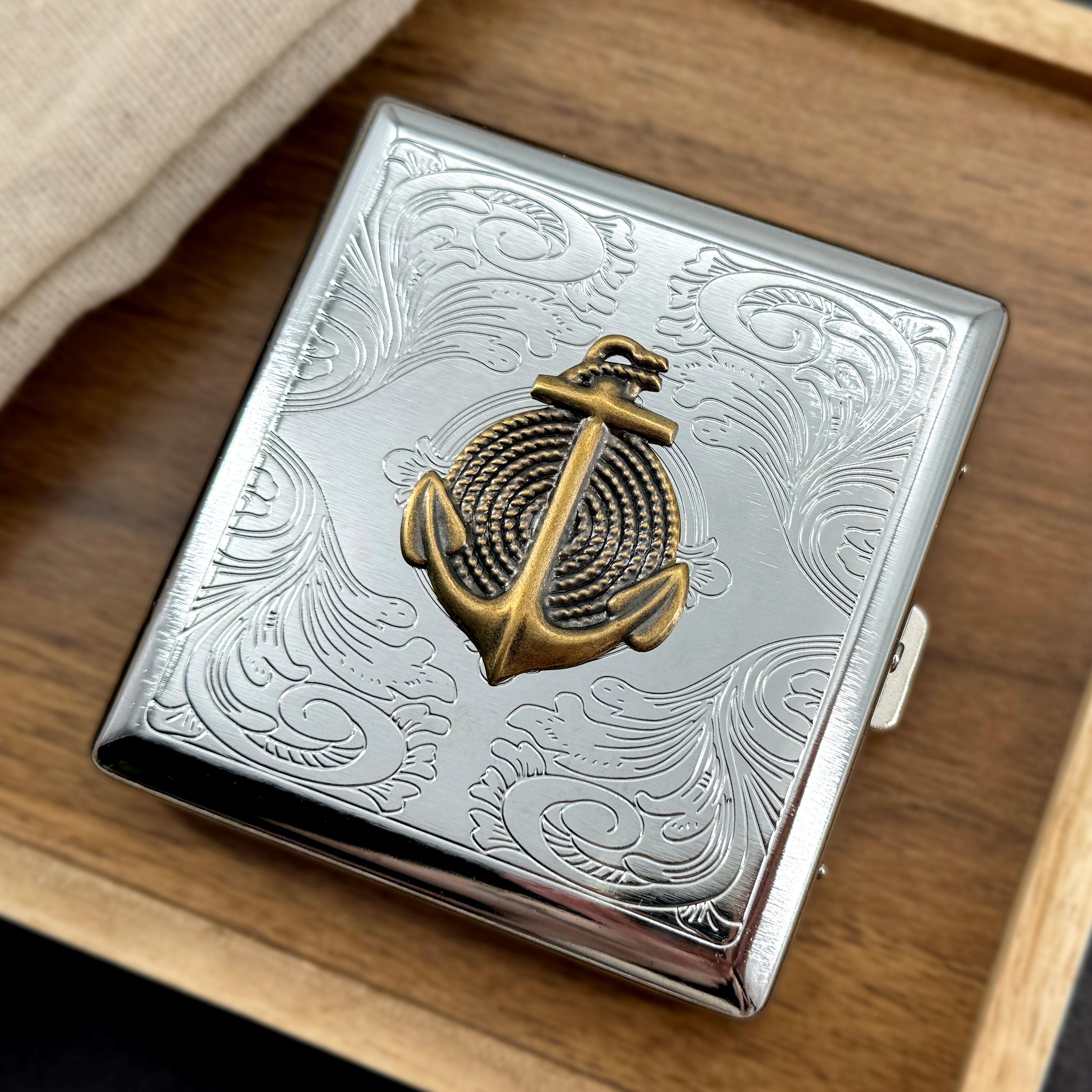 Stamped metal cigarette case with raised anchor and rope design