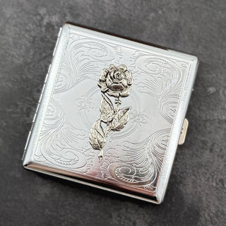 Botanical card holder with detailed silver rose and vintage-inspired floral scrollwork.
