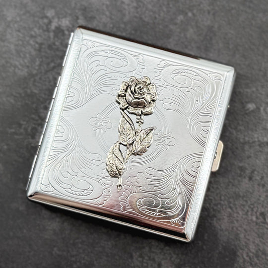 Botanical card holder with detailed silver rose and vintage-inspired floral scrollwork.