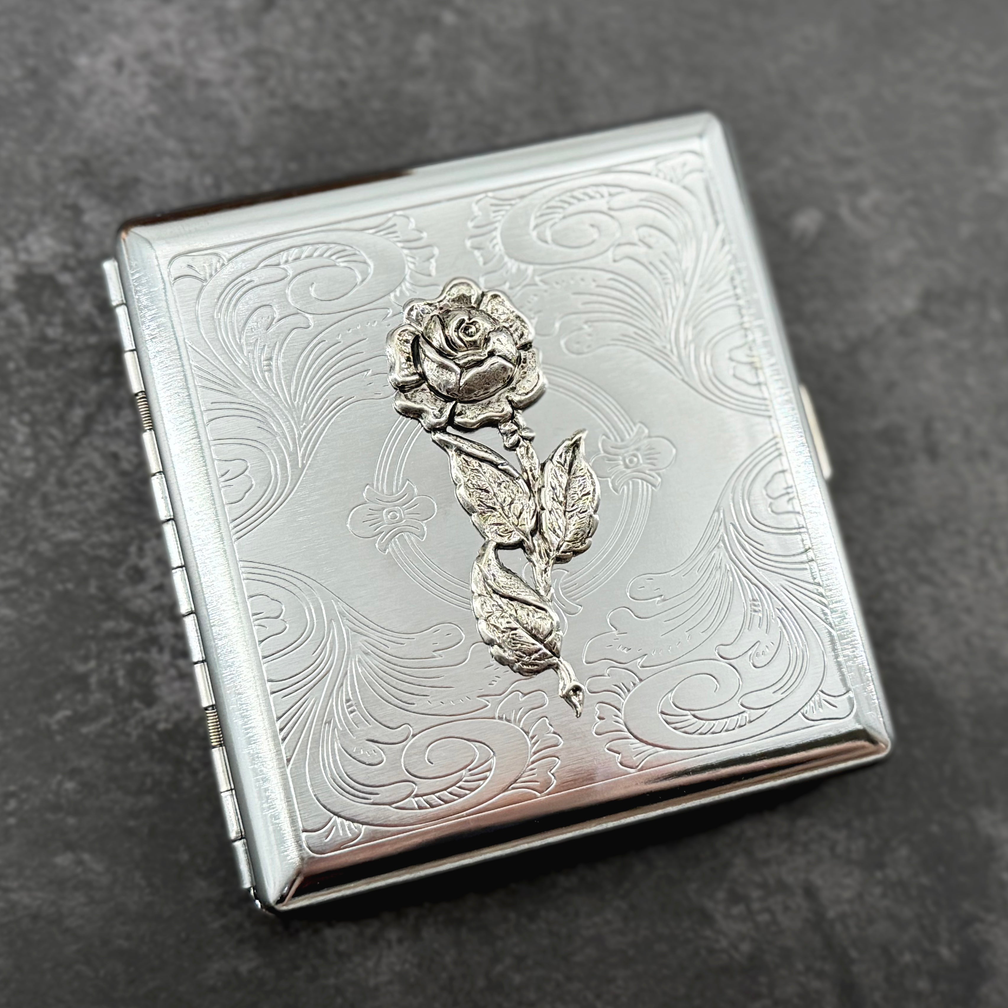 Elegant rose case with decorative botanical design and secure snap closure.
