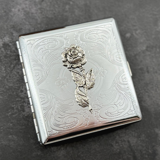 Elegant rose case with decorative botanical design and secure snap closure.