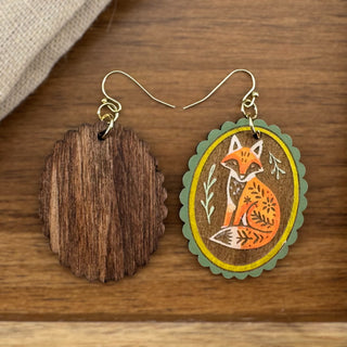 Handmade fox earrings featuring engraved botanical artwork and warm earthy tones