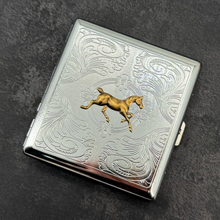 Front view of equestrian metal cigarette case with ornate stamped scrollwork design