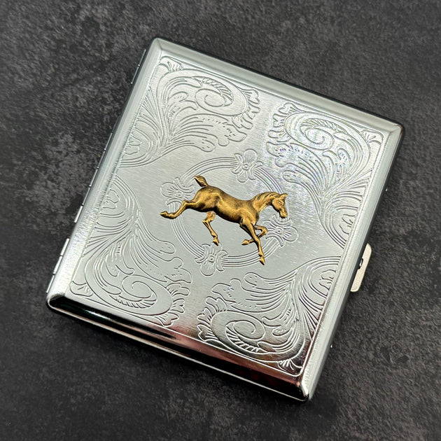 Front view of equestrian metal cigarette case with ornate stamped scrollwork design