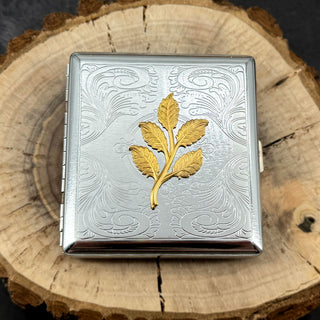 Handmade botanical cigarette case featuring a gold leaf branch on silver metal.