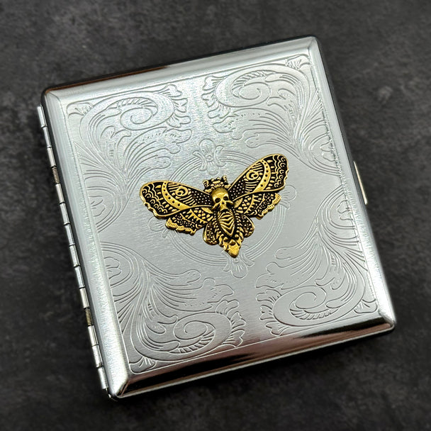 Victorian-inspired skull moth pocket case with intricate stamped metal background