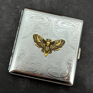 Golden Death's-head hawkmoth metal cigarette case with ornate stamped scrollwork background