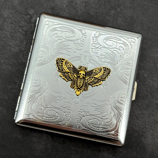 Golden Death's-head hawkmoth metal cigarette case with ornate stamped scrollwork background
