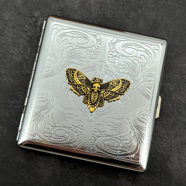 Golden Death's-head hawkmoth metal cigarette case with ornate stamped scrollwork background