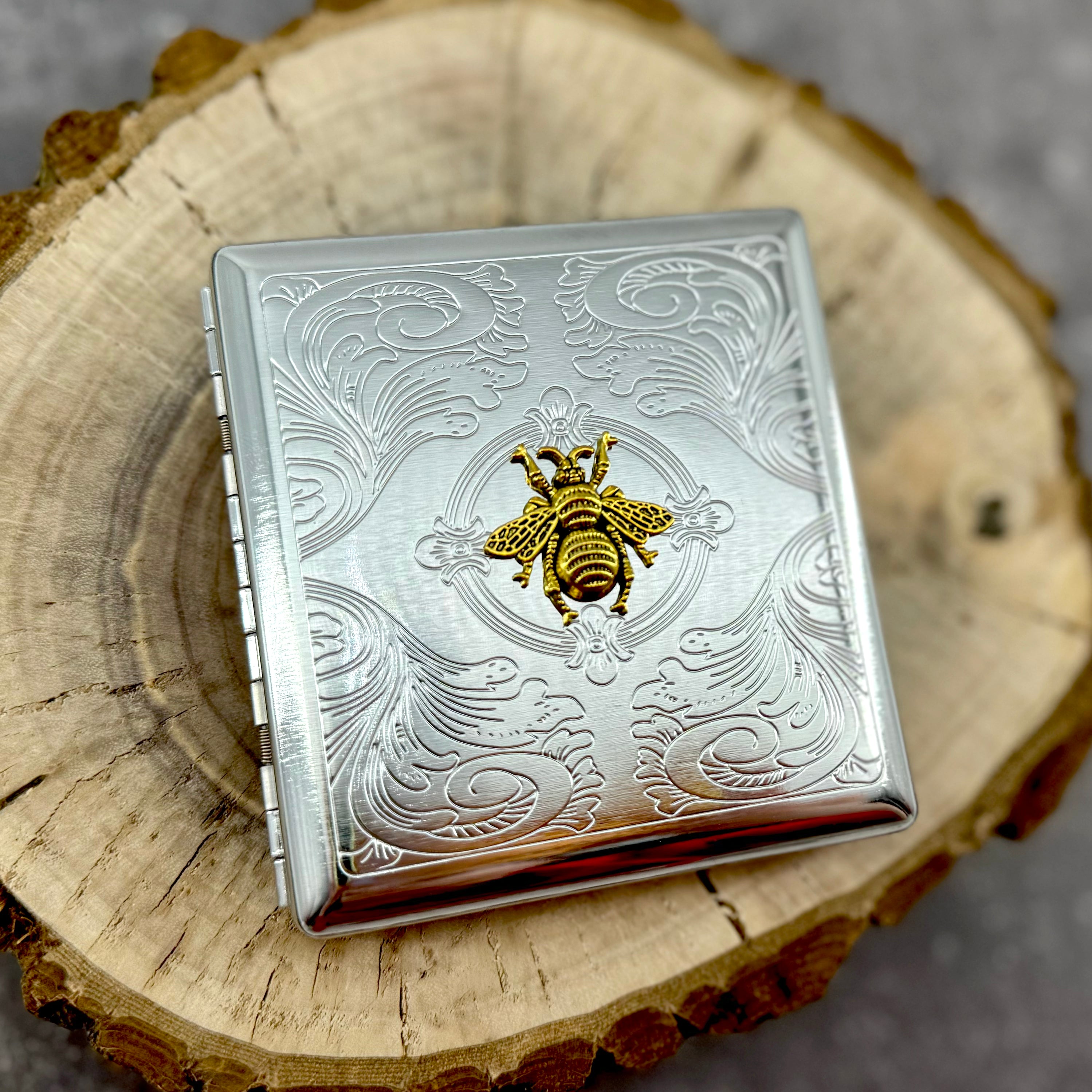 Queen Bee metal pocket case with raised gold bee emblem and stamped scrollwork