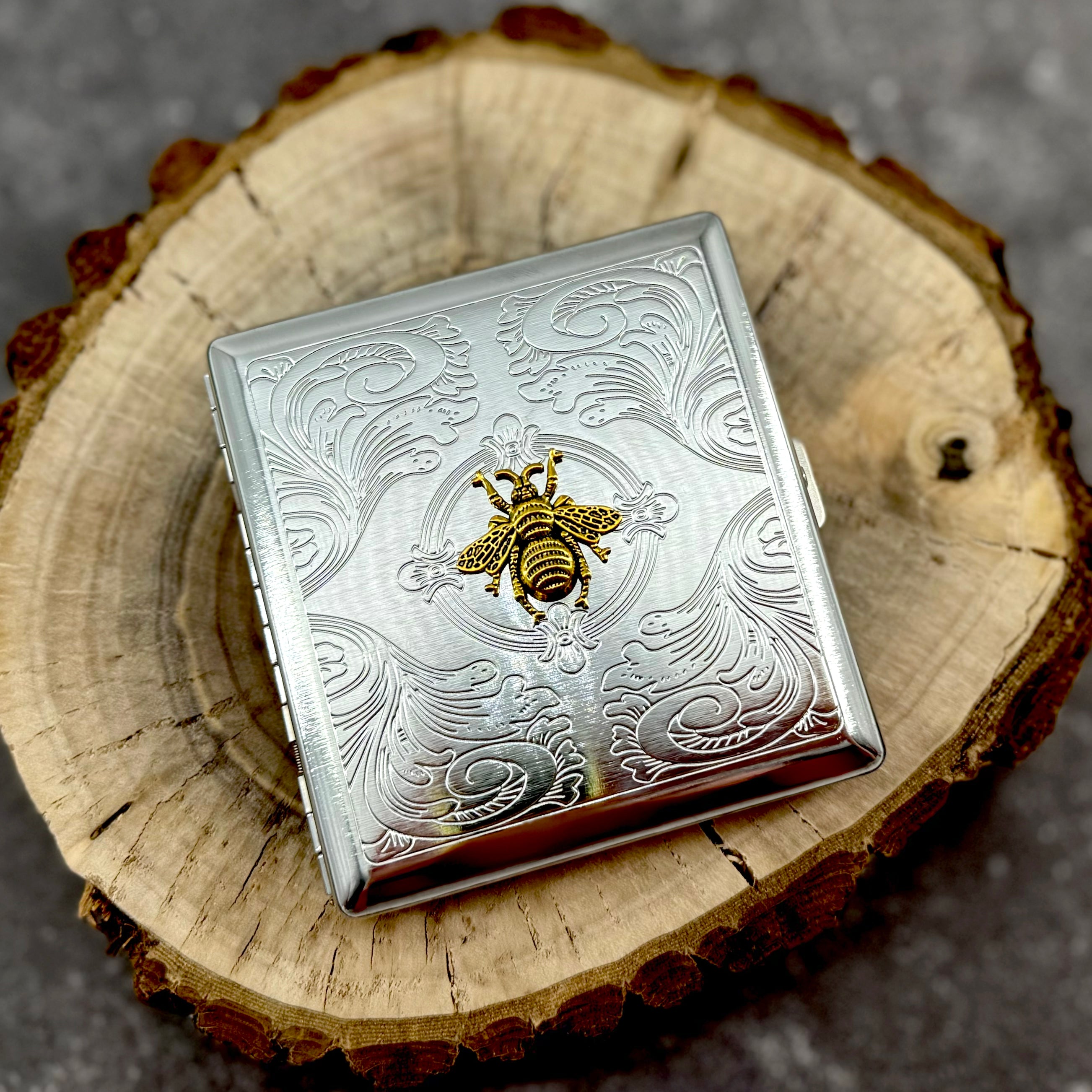 Bee card holder with decorative scrollwork and polished metal finish