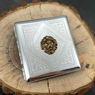 Regal Lion cigarette case with raised bronze lion head on silver stamped geometric background