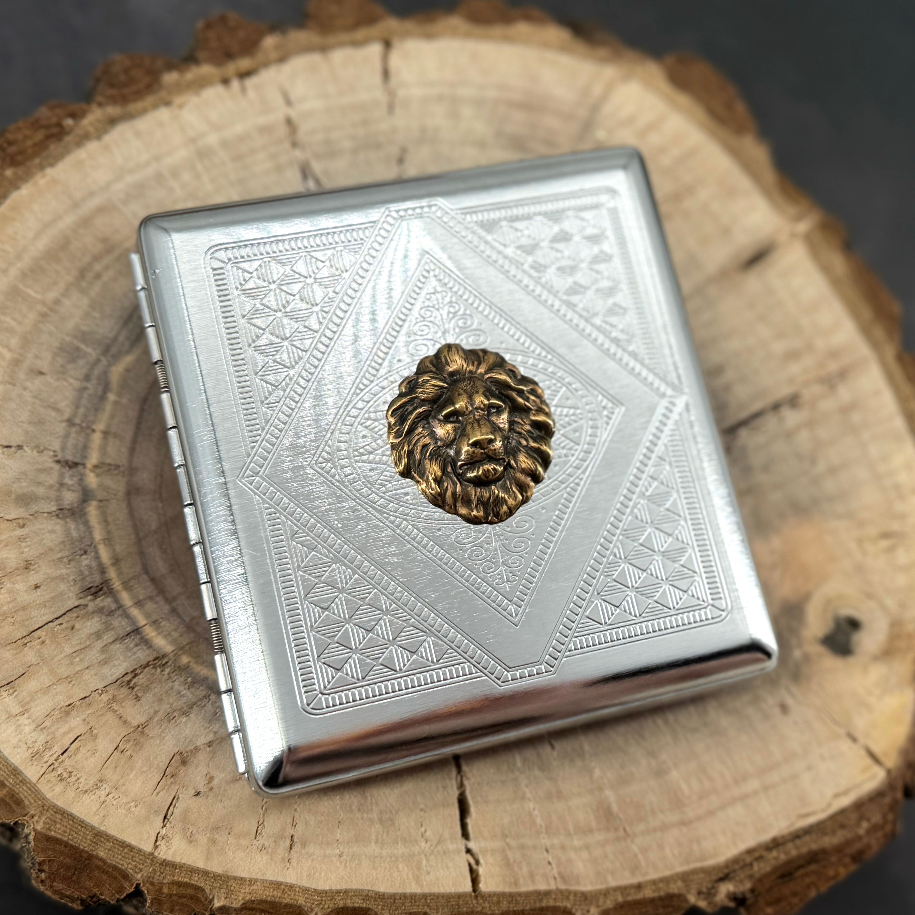 Regal Lion cigarette case with raised bronze lion head on silver stamped geometric background