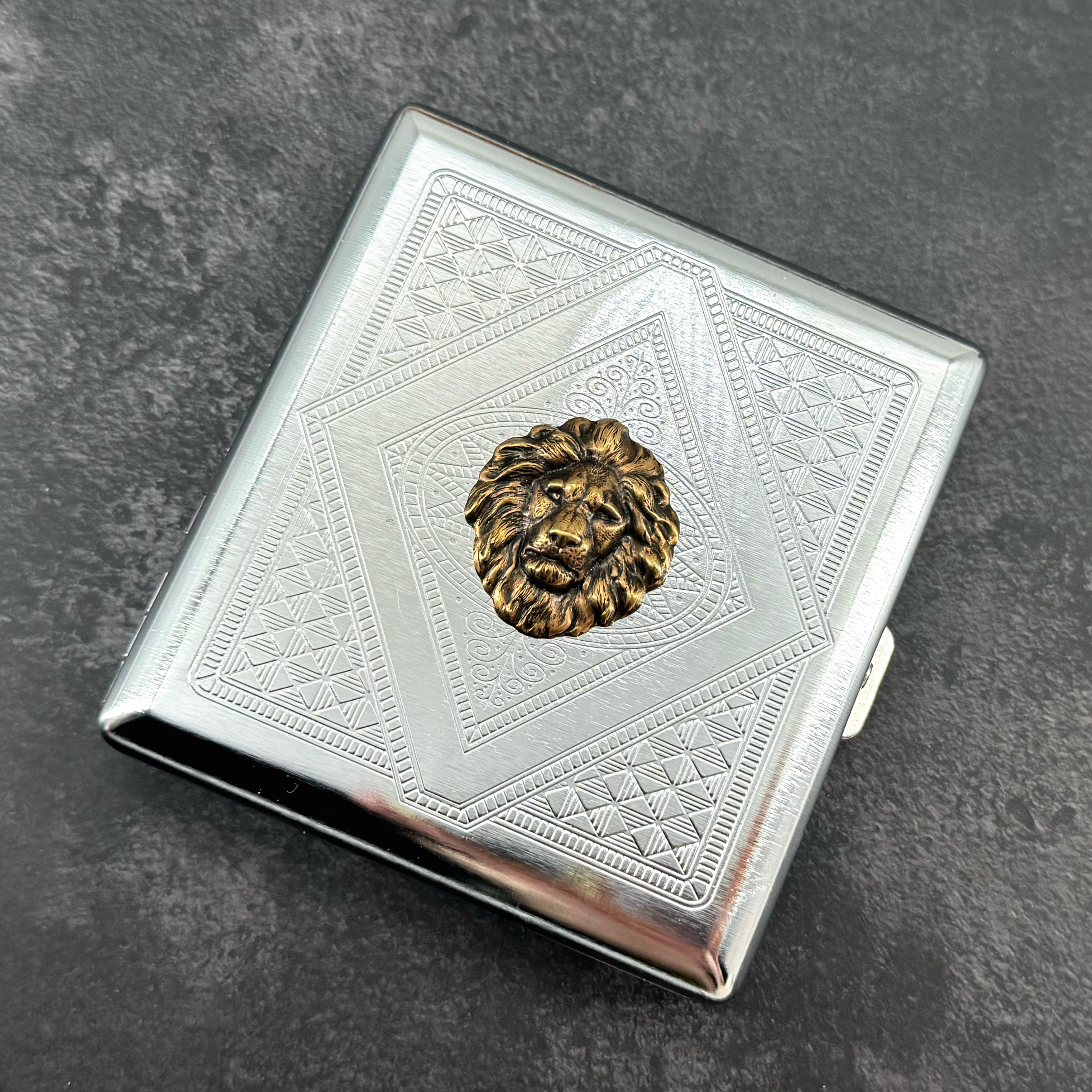 Handmade metal lion case featuring detailed engraved geometric pattern and bronze lion centerpiece
