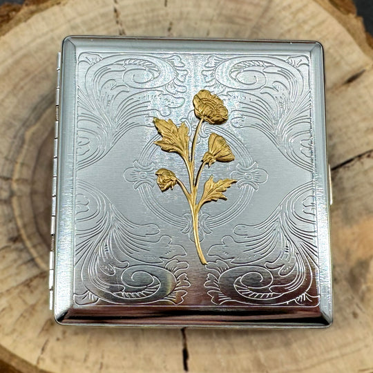 Silver stamped metal cigarette case with raised gold wildflower bouquet.
