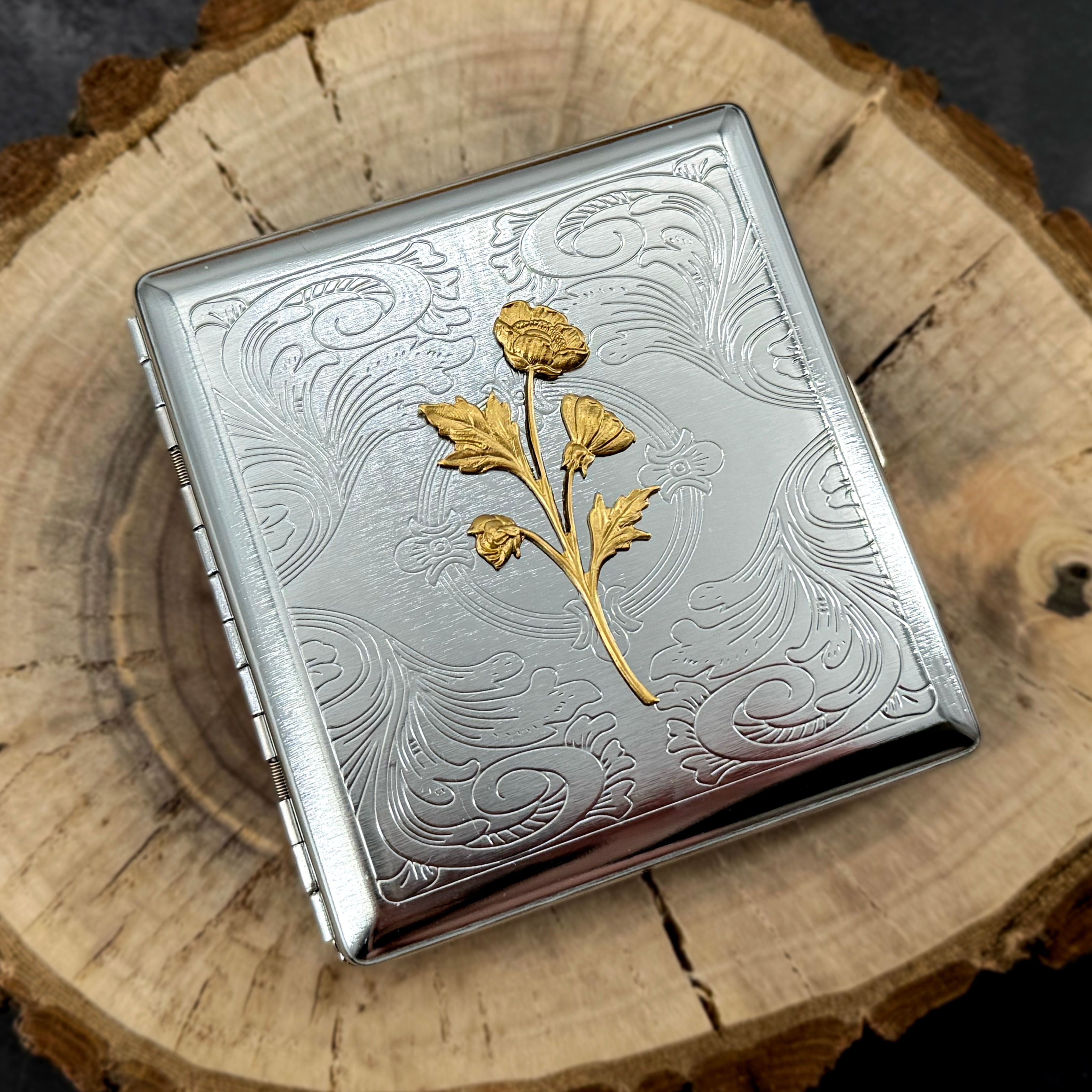 Handmade floral cigarette case featuring a gold botanical centerpiece.