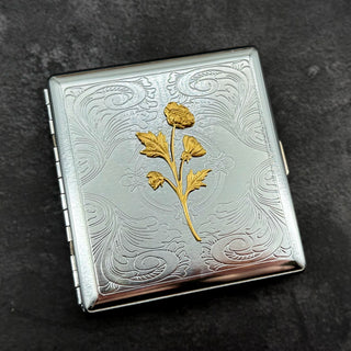 Ornate silver business card holder with raised wildflower decoration.