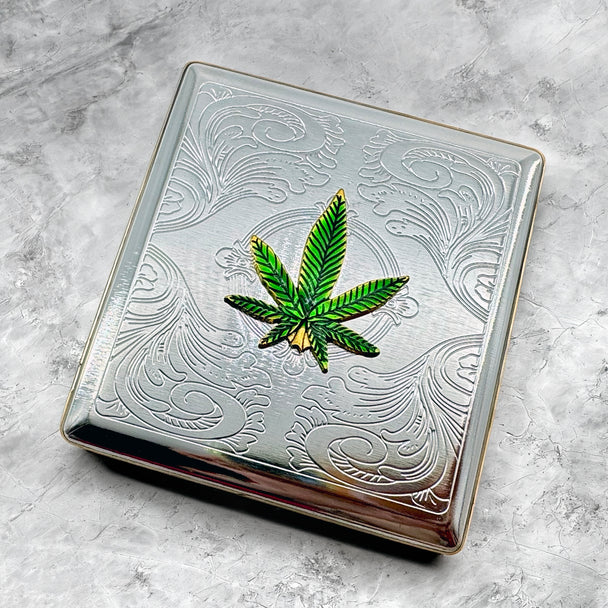 Green cannabis leaf cigarette case displayed on stone background