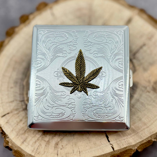 High Society metal pocket case with raised cannabis leaf emblem and stamped scrollwork