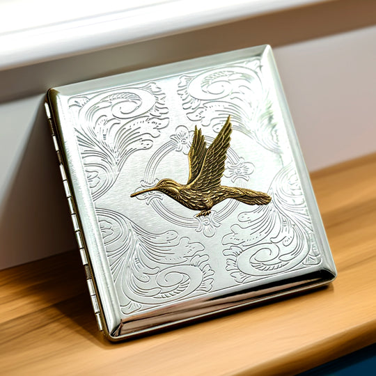 Hummingbird cigarette case with raised bird detail and engraved ornamental background