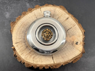 Round wildlife flask with transparent viewing window, bronze-toned lion head, and screw-top lid
