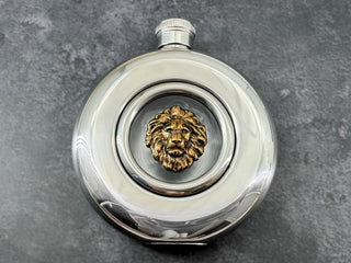 Lion flask with antique bronze-toned lion head centered in a clear circular viewing window