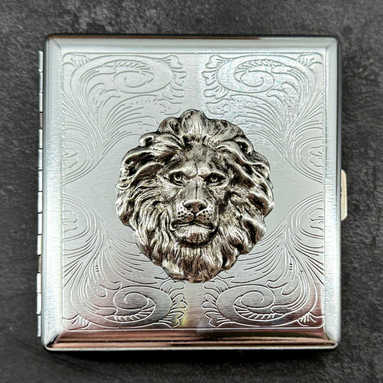 1. Lion head metal cigarette case with raised silver lion and ornate stamped scrollwork