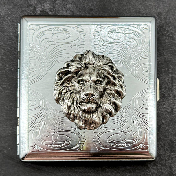 1. Lion head metal cigarette case with raised silver lion and ornate stamped scrollwork